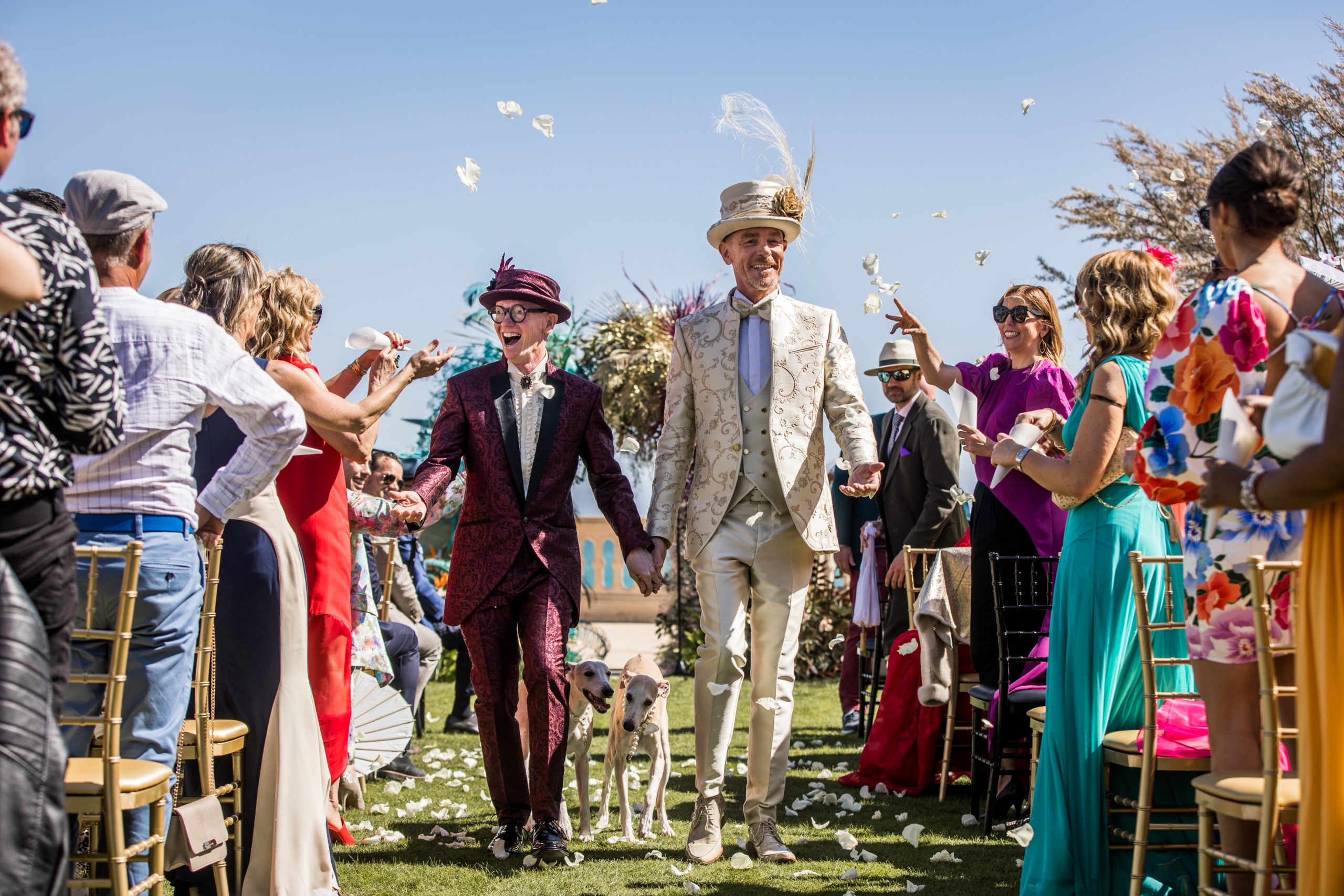 Adam and Salvador walk through confetti thrown by guests at their wedding
